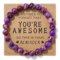 Detail van een paarse natuursteen kralenarmband op een kraftpapier geschenkkaart - Paarse Keizerssteen (YOU RE A W E S O Kaart)