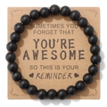 Detail van matte zwarte kralenarmband op kraft kaart met inspirerende tekst als cadeau - Matzwart (YOU RE A W E S O Kaart)
