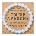 Elastische armband met witte stenen kralen op kraftpapier kaart met inspirerende tekst - Opalite (YOU RE A W E S O Kaart)