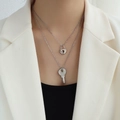 Double-layered silver necklace with heart lock and key pendants on female model - Silver Lock and Key Necklace Set
