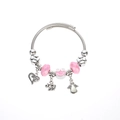 Close-up of pink frog pendant and silver beaded bracelet with heart and elephant charms - Pink