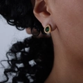 Orecchini a goccia dorati con pietre preziose verdi e cristalli bianchi su modella - Stile Goccia (F888)