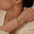Detail of gold ocean-themed shell and starfish jewelry set with pearls on a model - Conch Pearl Stud Earrings (GE947)