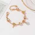 Gold snake chain bracelet featuring light blue enamel hearts and floral charms on a tray - Blue Sakura Flower Pendant 17cm