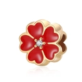 Macro shot of gold floral charm with red enamel petals and central sparkling zircon - Red