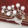 Broche de ciervo plateado con perlas blancas y pedrería brillante sobre fondo rojo - Plata Mate Perla Blanca
