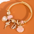 Bracciale regolabile in acciaio dorato con ciondoli a conchiglia di perle e fata - Rosa