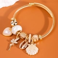 Bracciale rigido dorato regolabile in acciaio con ciondoli cuore, conchiglia e angelo - Bianco