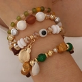 Mehrlagiges Boho-Perlenarmband mit Muschelanhängern und blauem Evil-Eye-Akzent - Grün Verlauf