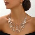 Boheemse meerlaagse kralenketting en kristallen oorbellenset op een vrouwelijk model - Wit