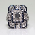 Art Déco Ring mit klarem Hauptstein und Saphir-Halo auf silbernem Edelstahlelement - US 6 / Blau Versilbert