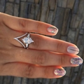 Close-up of a marquise cut stone ring set with a V-shaped eternity band on a finger - US 6 / White Gold
