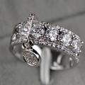 Macro shot of silver adjustable disc ring featuring micro-pave zircon and dangling charm - US 5 / Silver