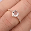 Macro detail of heart-shaped pink gemstone ring set in rose gold with diamond halo - US 5 / Rose Gold