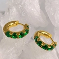 Elegante goldene Creolen mit smaragdgrünen Kristallen auf weißem Kristallhintergrund - Gold + Grüner Zirkonia