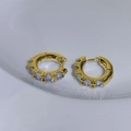 Elegante goldene Creolen mit funkelnden Zirkon-Kristallen auf weißer Keramikunterlage - Gold + Weißer Zirkonia