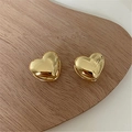 Macro detail of polished 3D gold heart earrings resting on a rustic wooden texture - Large (1.5cm) / Gold