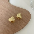 Detailed macro view of 3D polished golden heart-shaped hoop earrings on display - Medium (1.3cm) / Gold