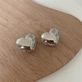 Detailed view of polished silver heart-shaped hoop earrings on a minimalist wooden tray - Large (1.5cm) / Silver
