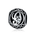 Macro view of vintage silver hollow charm bead with letter engraving and cubic zirconia - Letter G