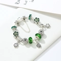 Bracelet chaîne serpent en argent avec perles en verre vert et breloques trèfle sur fond blanc - Vert
