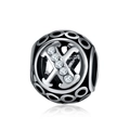 Macro shot of silver hollow bead charm with letter X and sparkling zircon stones - Letter X