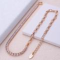 Macro shot of gold-plated tennis bracelet and cuban chain with Hand Made tag - Gold