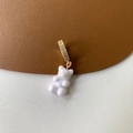 Macro view of a white resin gummy bear charm with a gold-plated diamond-set clasp - Micropaved White Bear Pendant