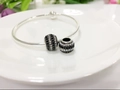 Detailed shot of silver open bangle with black and white crystal pave bead charms - Black & White