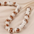 Macro detail of blue and white ceramic beads with orange floral patterns on silk - Style 1
