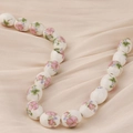 Vista detallada de cuentas de cerámica ovaladas con motivos florales rosas - Estilo 6