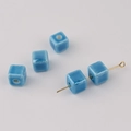 Macro shot of sky blue cube ceramic beads with vertical holes for DIY jewelry making - Aqua