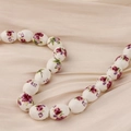 Detalle macro de cuentas de cerámica blanca con flores púrpuras sobre seda color beige - Estilo 9#