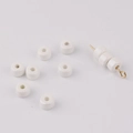 Macro shot of cream ceramic wheel beads with smooth glaze and gold needle for DIY jewelry - White