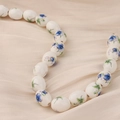 Detalle de cuentas ovaladas de cerámica azul y blanca sobre seda con acabado brillante - Estilo 7#
