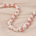 Detalle macro de cuentas de cerámica blanca con flores de ciruelo sobre tela seda - Estilo 13