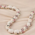 Detalle de cuentas de cerámica con motivos florales rosas y texto Orchid sobre seda - Estilo 11