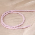 Vue macro de perles en verre givré lavande mat sur un fond en tissu de soie champagne - Taille 8