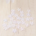 Flat lay of iridescent resin five-petal flowers for DIY nail art and phone case decor - White