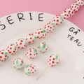 Macro view of handmade glass strawberry beads with gold eye pins on a pink background - Single Bead / White