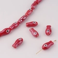 Macro detail of red ceramic fish beads with glossy glaze for DIY jewelry making - Red
