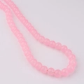Gros plan de perles en verre rose translucide sur un fil pour la création de bijoux - Taille 8