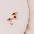 Macro detail of gold tree branch jewelry connector with three red marquise cut zircons - Red Branch