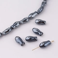 Macro shot of fish-shaped beads with dark metallic finish and eye detail for DIY jewelry - Dark Gray