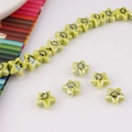 Macro shot of light green ceramic star beads with smiley faces for DIY jewelry making - Grass Green