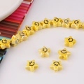 Macro view of a yellow ceramic star bead with a smiley face for DIY handmade jewelry - Yellow
