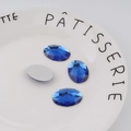 Detailed view of faceted sapphire blue oval acrylic rhinestones with flat back design - Standard Spec / Sapphire Blue