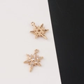 Macro detail of gold North Star charms with sparkling cubic zirconia insets - North Star Octagonal Style