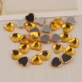 Detailed macro view of 12mm amber heart-shaped flatback acrylic rhinestones for DIY crafts - Gold Yellow