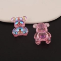 Detail view of two aurora pink iridescent resin bear charms with a holographic finish - Style 4 (Ruby Red)